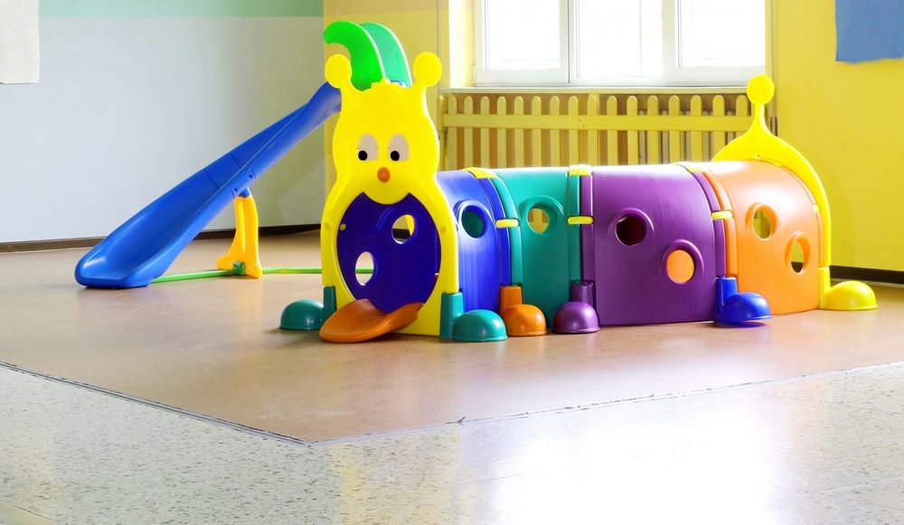 Zona de juego interior con tobogán y estructura de colores